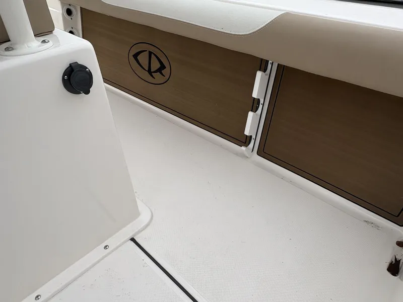 Slide: The Image of 2025 Sea Born LX LX24 boat interior with storage compartments and beige seating. - 11