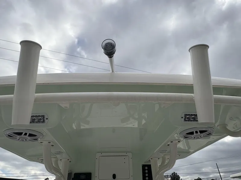 Slide: The Image of 2025 Sea Born LX LX24 boat roof with rod holders and speakers under cloudy sky. - 15