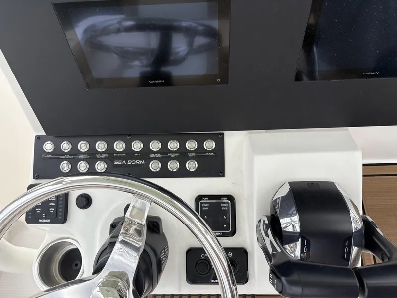 Slide: The Image of Control panel of 2025 Sea Born LX24 boat with steering wheel and Garmin displays. - 18