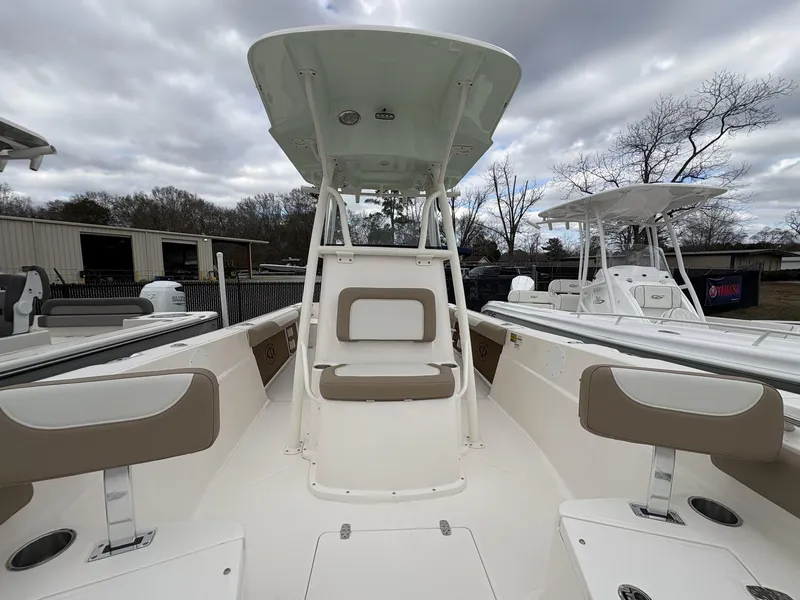 Slide: The Image of 2025 Sea Born LX LX24 boat interior with seating and T-top under cloudy sky. - 25