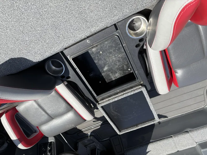 Slide: The Image of 2023 Phoenix 920 Elite boat interior with gray and red seats, cup holders, and storage compartments. - 11