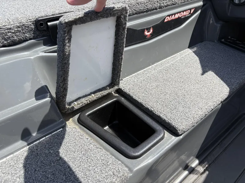 Slide: The Image of 2023 Phoenix 920 Elite boat storage compartment with carpeted lid and Diamond V hull design. - 15