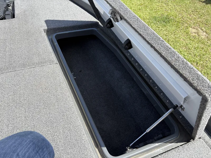 Slide: The Image of Open storage compartment on 2023 Phoenix 920 Elite boat, featuring carpeted interior. - 20