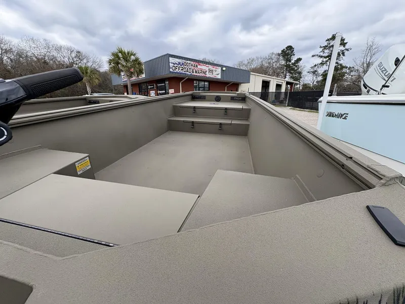 Slide: The Image of 2025 Thor Lake Hammer Hybrid 1754 boat interior at dealership, under cloudy sky. - 5