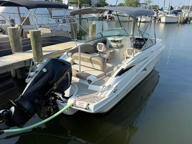 Slide: The Image of 2023 Crownline Eclipse E235 XS boat docked at marina, featuring sleek design and spacious seating. - 13