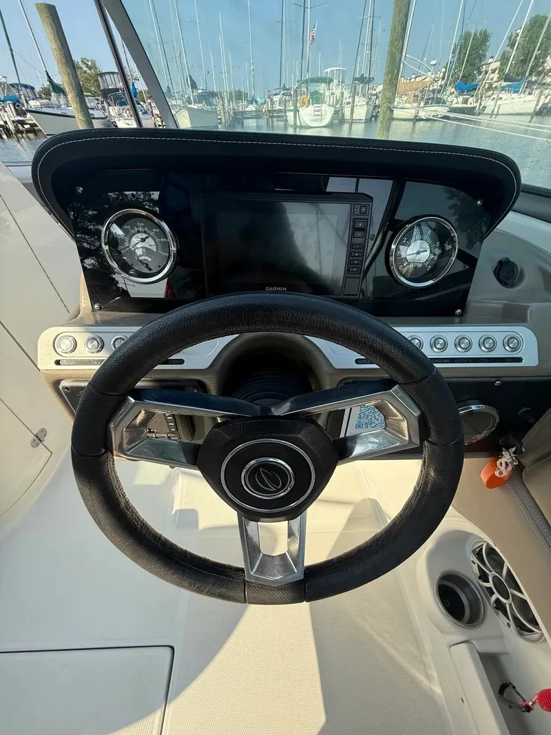 Slide: The Image of 2023 Crownline Eclipse E235 XS boat dashboard with steering wheel and navigation system. - 15