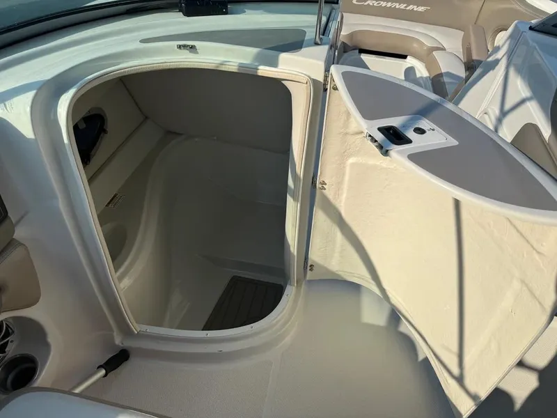 Slide: The Image of 2023 Crownline Eclipse E235 XS boat interior with open storage compartment. - 19