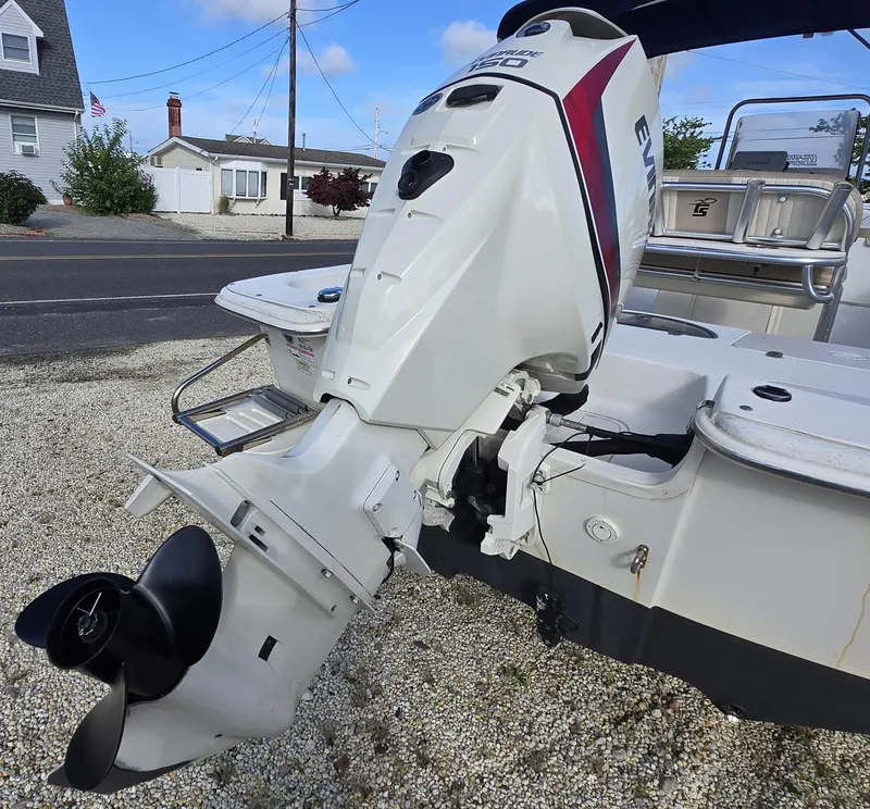 Slide: The Image of 2016 Carolina Skiff 238 DLV with Evinrude 150 outboard motor, parked on gravel. - 19