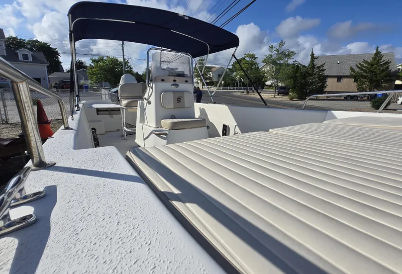 Slide: The Image of 2016 Carolina Skiff 238 DLV boat with canopy, parked outdoors under a blue sky. - 8