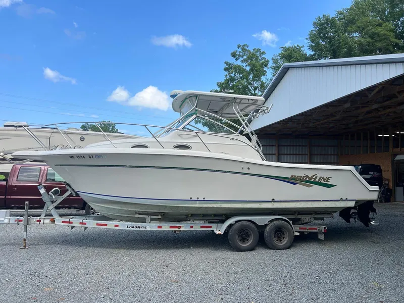 The Image of 1997 Pro-Line 2810 Walkaround boat on trailer, parked outdoors under blue sky. - 0