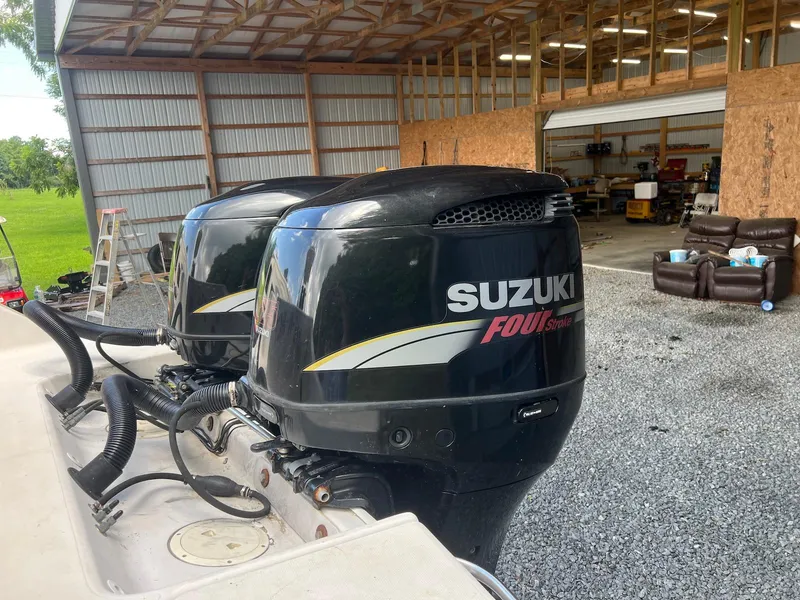 Slide: The Image of Twin Suzuki Four Stroke engines on a 1997 Pro-Line 2810 Walkaround boat in a garage. - 14