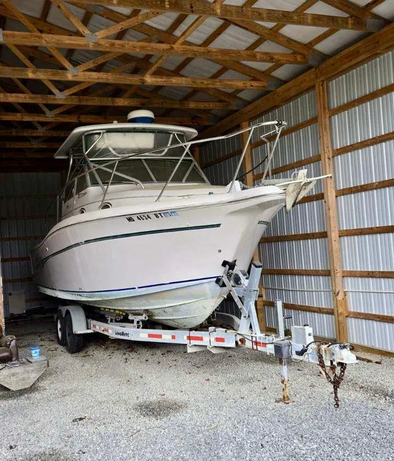 Slide: The Image of 1997 Pro-Line 2810 Walkaround boat stored in a metal shed on a trailer. - 4