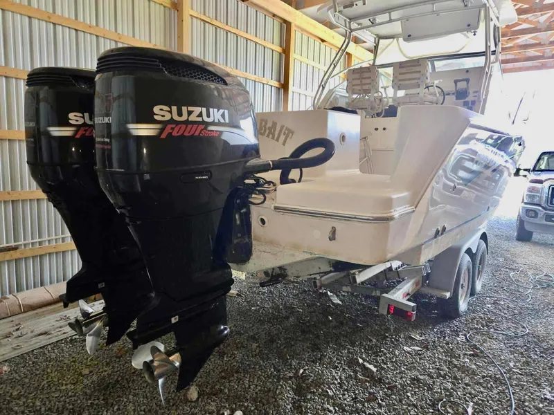 Slide: The Image of 1997 Pro-Line 2810 Walkaround boat with dual Suzuki four-stroke engines in a garage. - 5