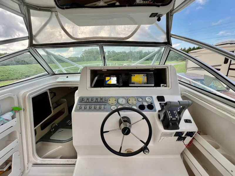 Slide: The Image of 1997 Pro-Line 2810 Walkaround boat cockpit with steering wheel and navigation equipment. - 6