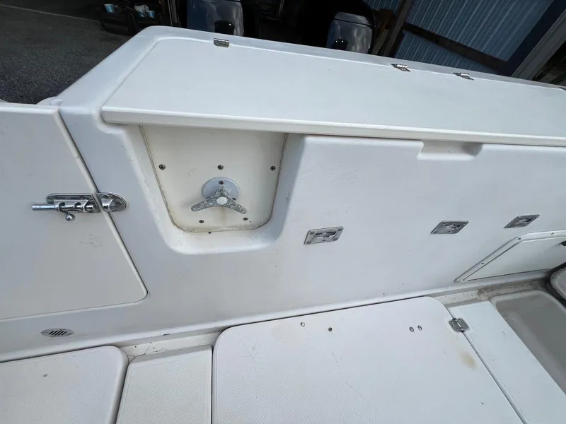 Slide: The Image of 1997 Pro-Line 2810 Walkaround boat deck with storage compartments and latch details. - 7