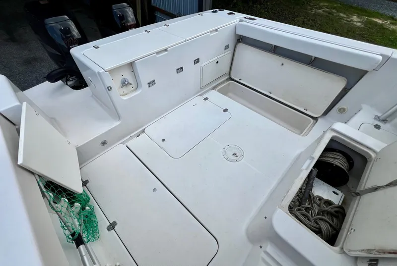 Slide: The Image of 1997 Pro-Line 2810 Walkaround boat deck with storage compartments and fishing gear. - 8