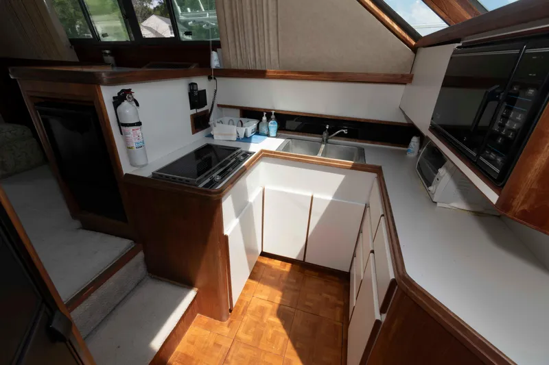 Slide: The Image of 1989 Tiara Yachts 36 Convertible kitchen with stove, sink, and microwave. - 12