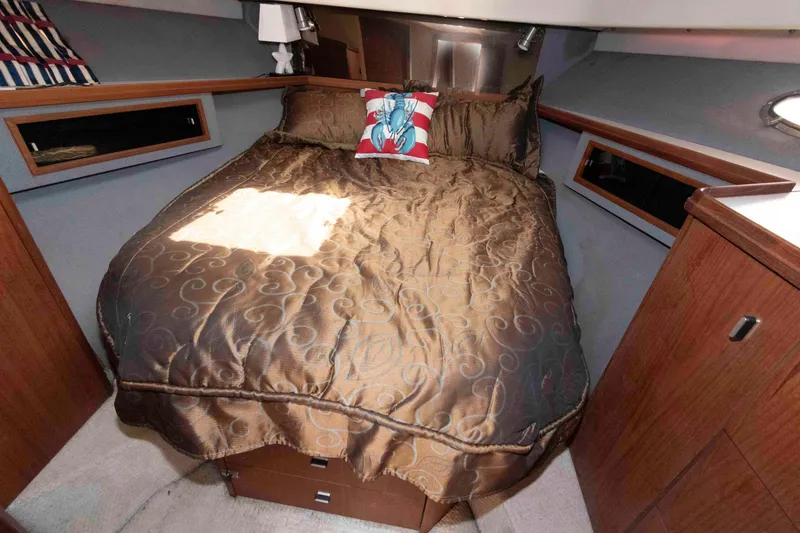 Slide: The Image of Cozy cabin interior of 1989 Tiara Yachts 36 Convertible with elegant bedding and wooden accents. - 13