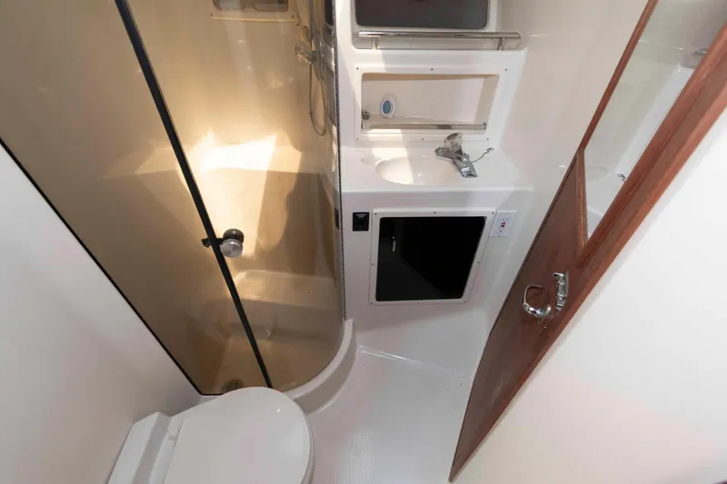 Slide: The Image of 1989 Tiara Yachts 36 Convertible bathroom with shower, sink, and toilet. - 14