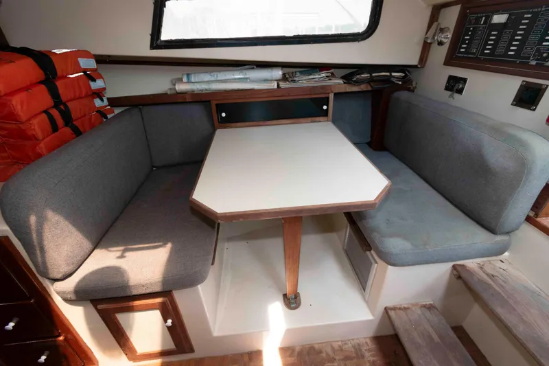 Slide: The Image of Cozy interior of 1986 Shannon Brendan 32 boat with seating, table, and life jackets. - 13