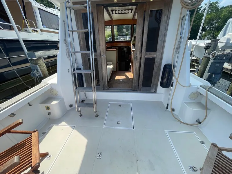 Slide: The Image of 1986 Shannon Brendan 32 boat deck with wooden chairs and cabin entrance. - 3