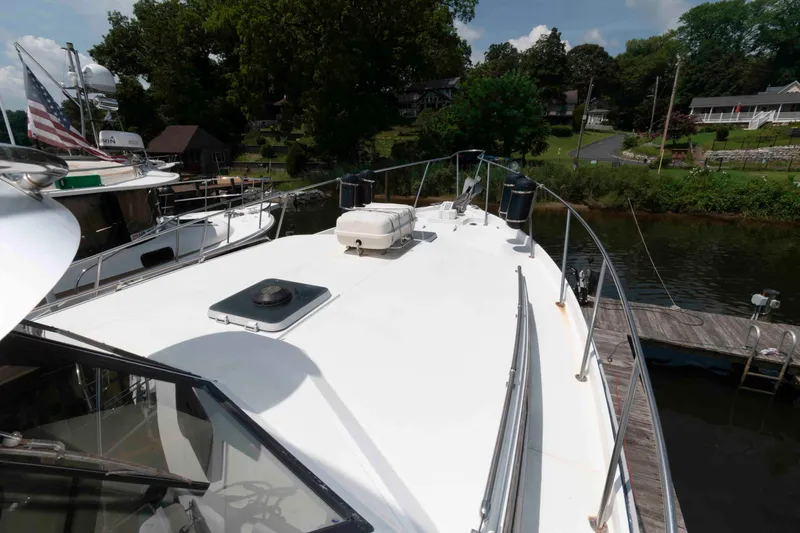 Slide: The Image of 1986 Shannon Brendan 32 yacht docked by a scenic riverside with lush greenery. - 6