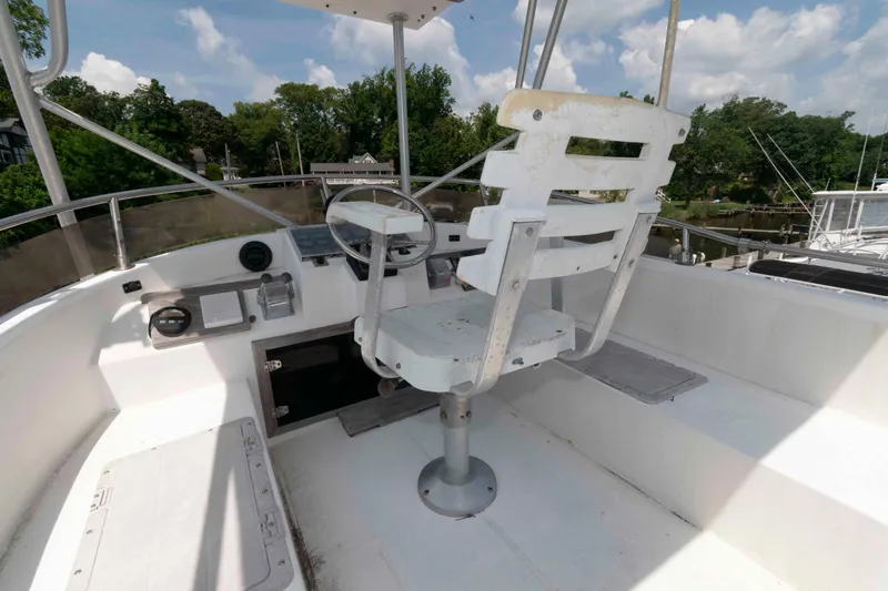 Slide: The Image of Captain's chair on 1986 Shannon Brendan 32 boat, featuring helm controls and scenic background. - 7