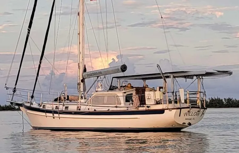 Slide: The Image of 2005 Cabo Rico 42 Pilot sailboat on calm water at sunset. - 1
