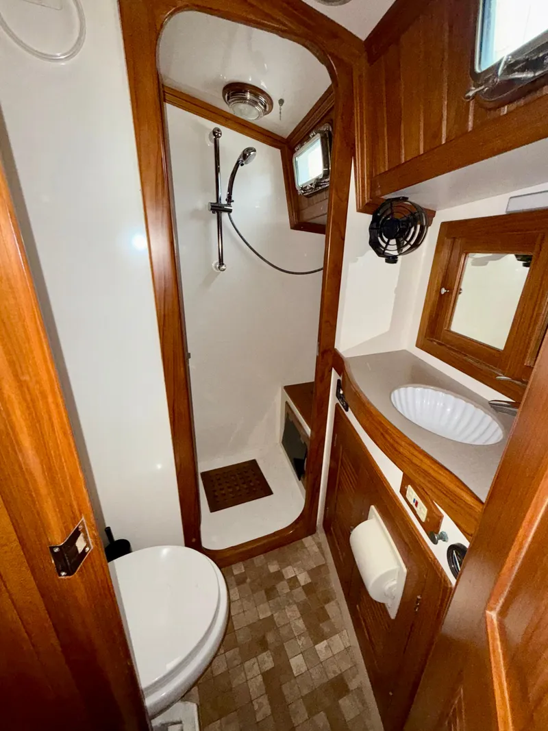 Slide: The Image of 2005 Cabo Rico 42 Pilot yacht bathroom with shower, sink, and wooden cabinetry. - 8