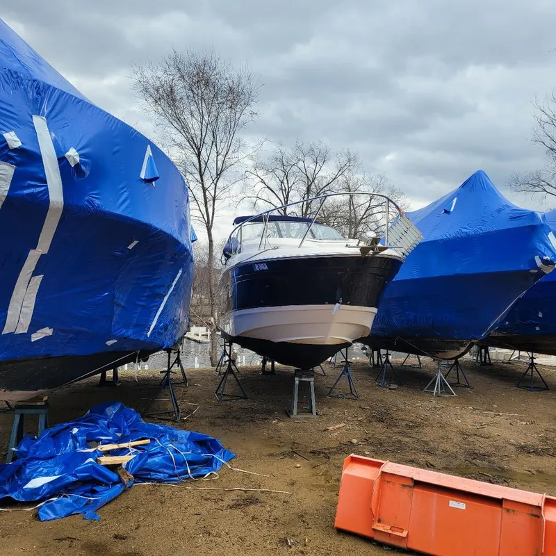 Slide: The Image of 2005 Chaparral 270 Signature boat stored on land, surrounded by blue tarps. - 3