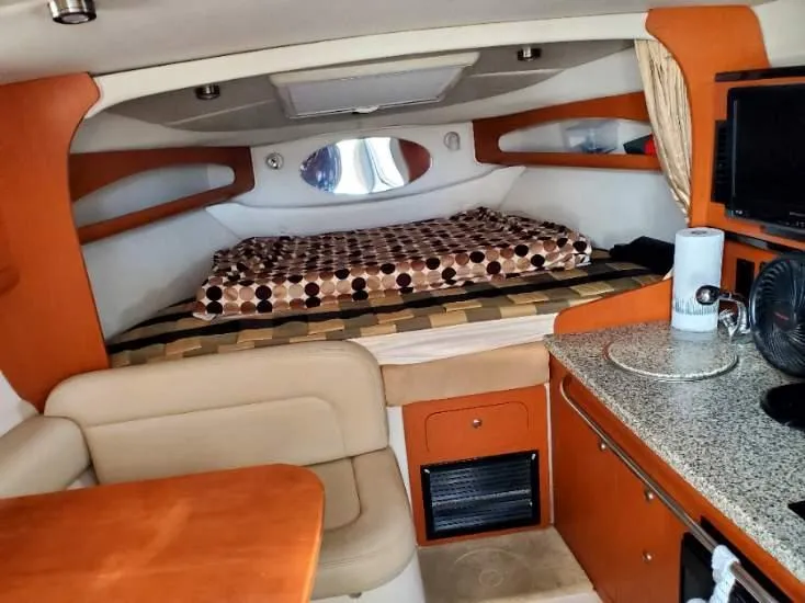 Slide: The Image of 2005 Chaparral 270 Signature cabin interior with bed, seating, and kitchenette. - 5