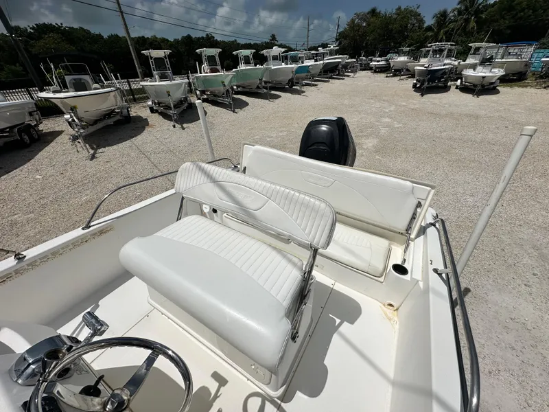 Slide: The Image of 2010 Boston Whaler 200 Dauntless boat interior with white seating and steering wheel. - 14
