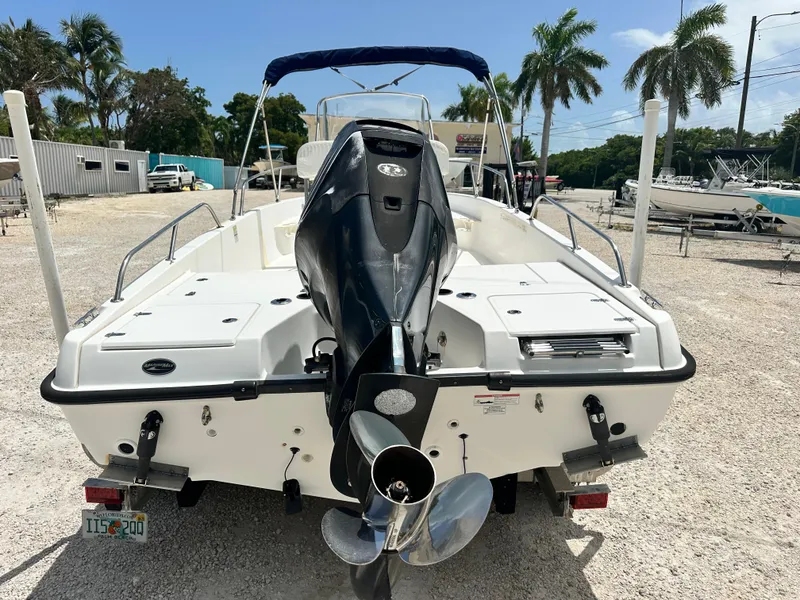 Slide: The Image of 2010 Boston Whaler 200 Dauntless boat with outboard motor, parked on gravel lot. - 4
