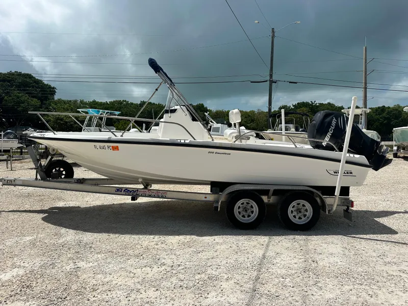 Slide: The Image of 2010 Boston Whaler 200 Dauntless boat on trailer, parked outdoors. - 6