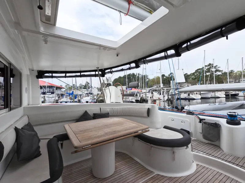 Slide: The Image of Spacious cockpit of 2013 Nautitech 442 catamaran with seating and table, docked at marina. - 4