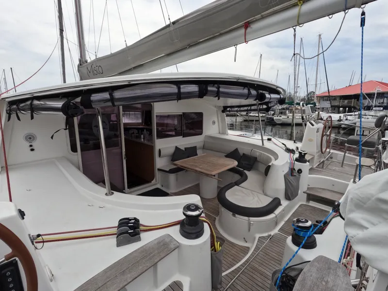 Slide: The Image of 2013 Nautitech 442 catamaran with spacious cockpit and seating area in marina. - 5