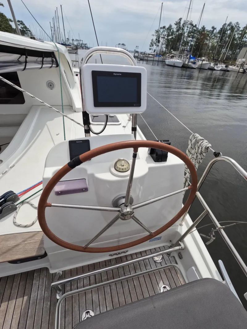 Slide: The Image of Steering wheel and navigation system on a 2013 Nautitech 442 catamaran docked at a marina. - 6