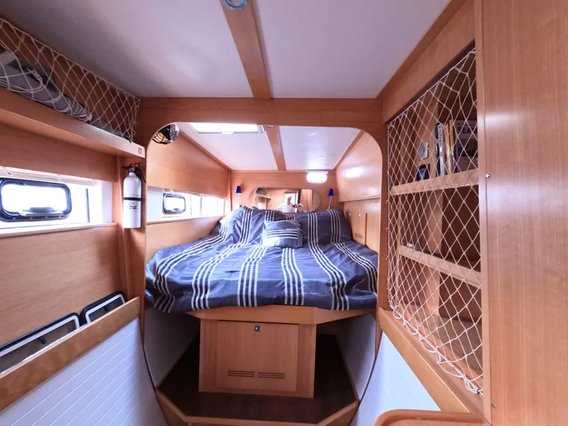 Slide: The Image of Cozy cabin interior of 2013 Nautitech 442 catamaran with striped bedding and wooden finish. - 8