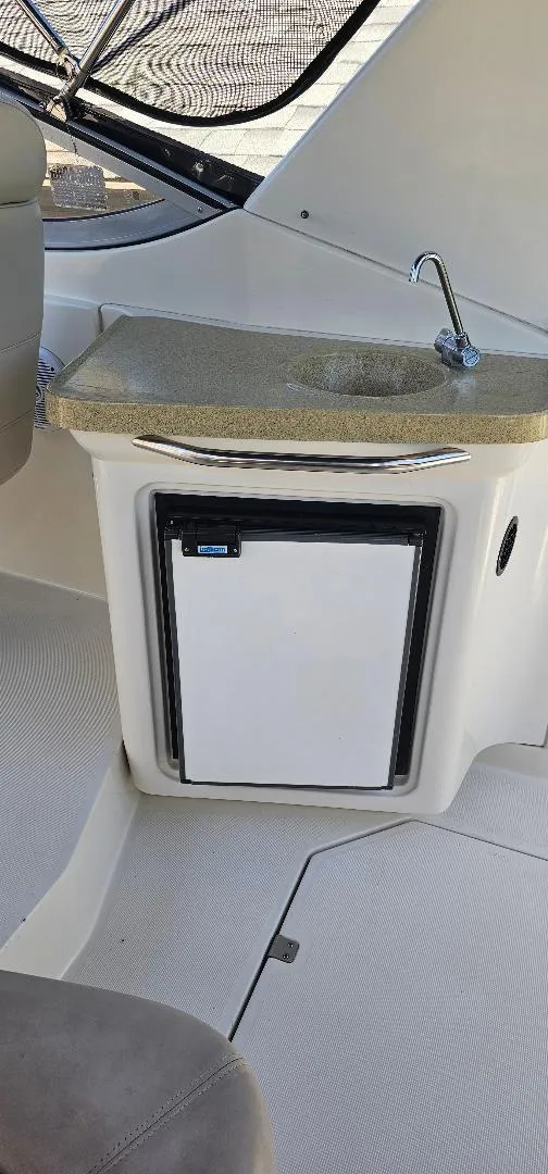 Slide: The Image of 2002 Regal Commodore 3060 boat interior with sink and mini fridge. - 3