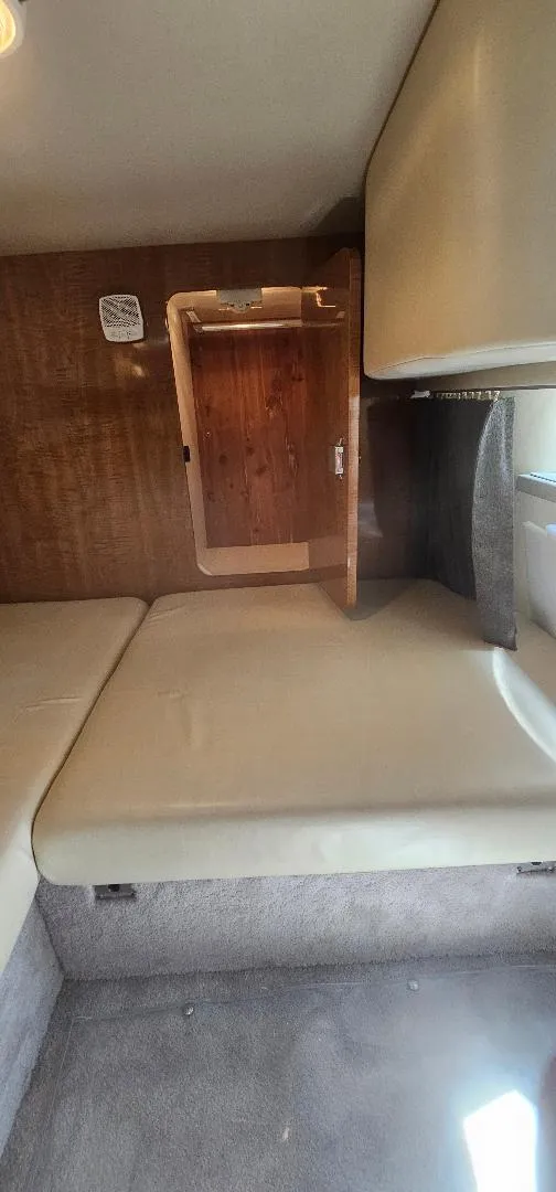 Slide: The Image of Interior cabin of 2002 Regal Commodore 3060 boat with beige seating and wooden accents. - 8