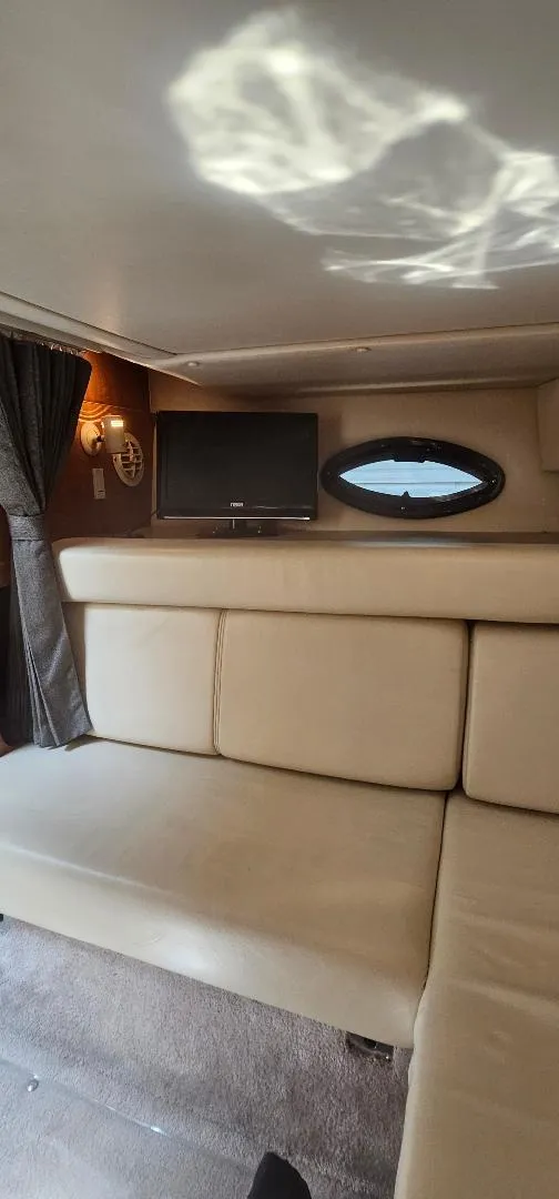 Slide: The Image of Interior of 2002 Regal Commodore 3060 yacht with beige seating and wall-mounted TV. - 9