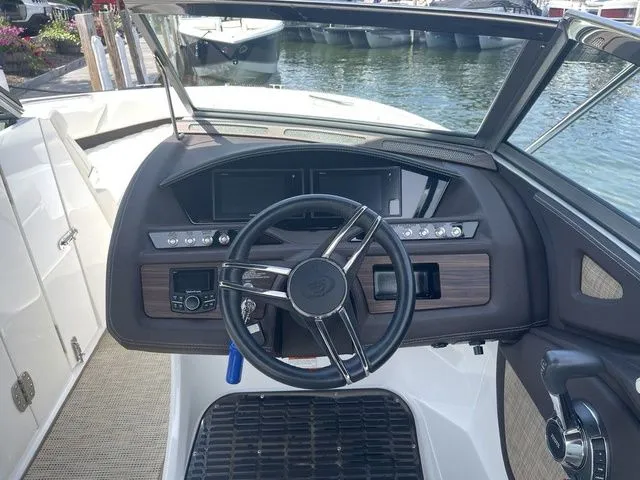 Slide: The Image of 2019 Cobalt R5 boat dashboard with steering wheel and control panel, docked by the water. - 17