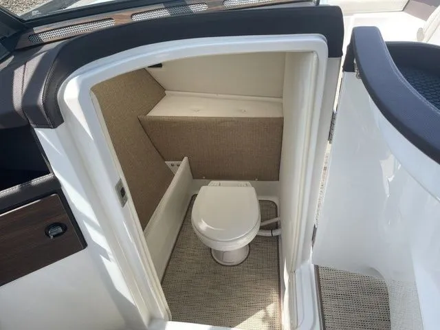 Slide: The Image of 2019 Cobalt R5 boat interior with compact marine toilet and beige paneling. - 20