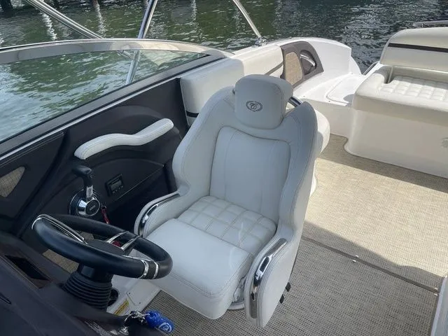 Slide: The Image of 2019 Cobalt R5 boat interior with white captain's chair and steering wheel, docked by water. - 22