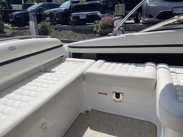 Slide: The Image of 2019 Cobalt R5 boat interior with white cushioned seating and parked cars in the background. - 24