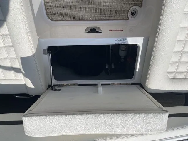Slide: The Image of Open storage compartment on a 2019 Cobalt R5 boat, featuring white cushioned seating. - 27