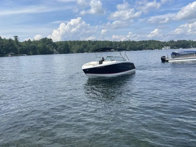 Slide: The Image of 2019 Cobalt R5 boat cruising on a serene lake under a partly cloudy sky. - 6