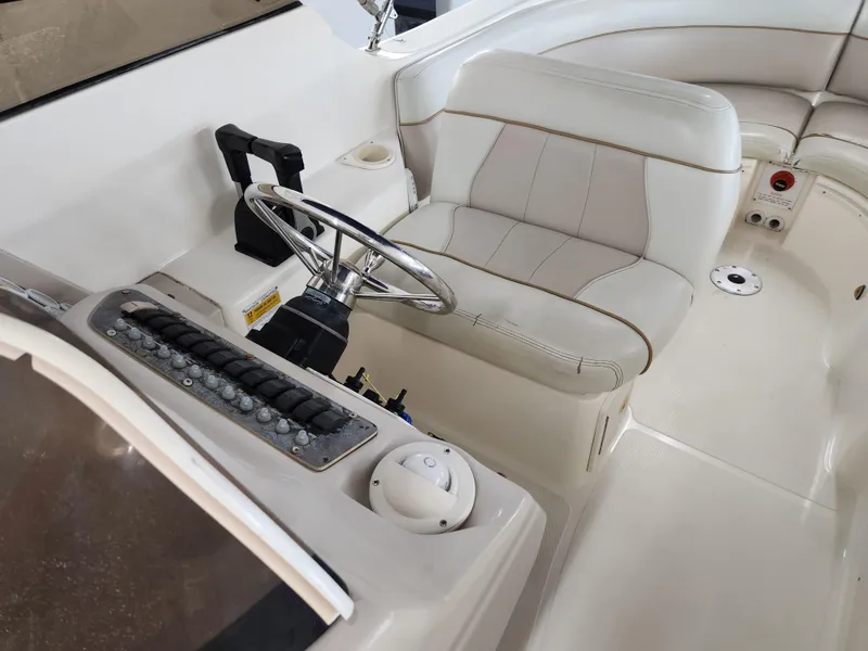 Slide: The Image of Interior of a 2000 World Cat 266 Leisure Cat boat, featuring steering wheel and seating. - 14