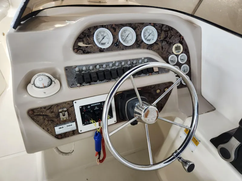 Slide: The Image of Control panel of a 2000 World Cat 266 Leisure Cat boat with steering wheel and gauges. - 18