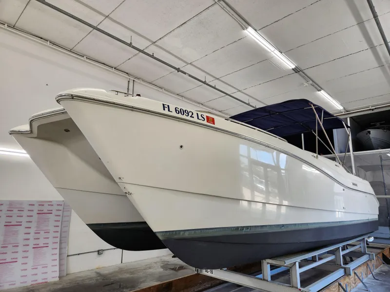 Slide: The Image of 2000 World Cat 266 Leisure Cat boat in indoor storage, featuring a sleek white hull. - 3